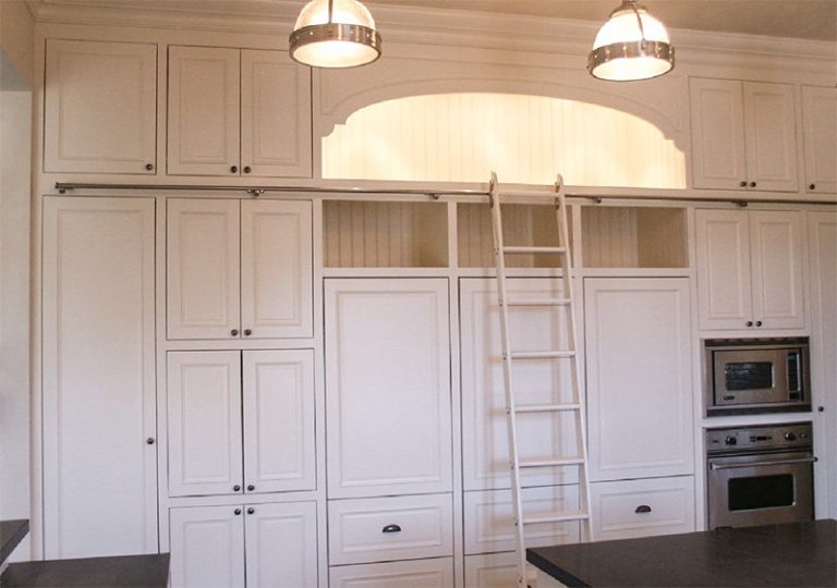 Painted kitchen cabinetry with a library ladder