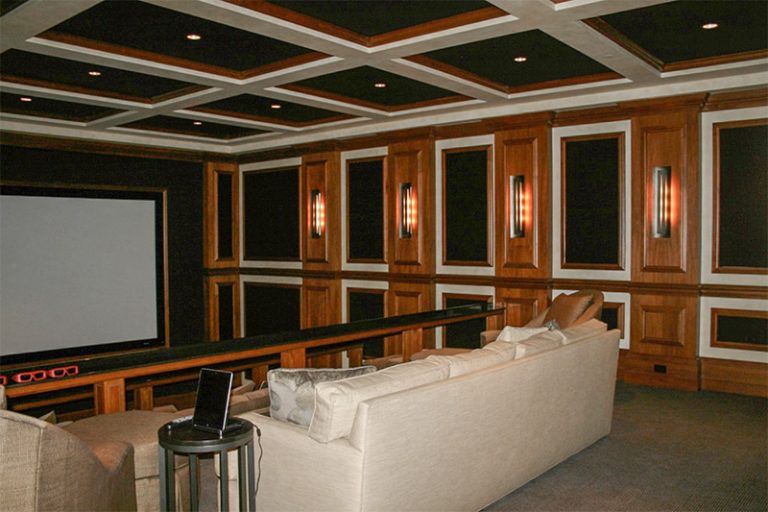 Media room with a coffered ceiling and paneled walls